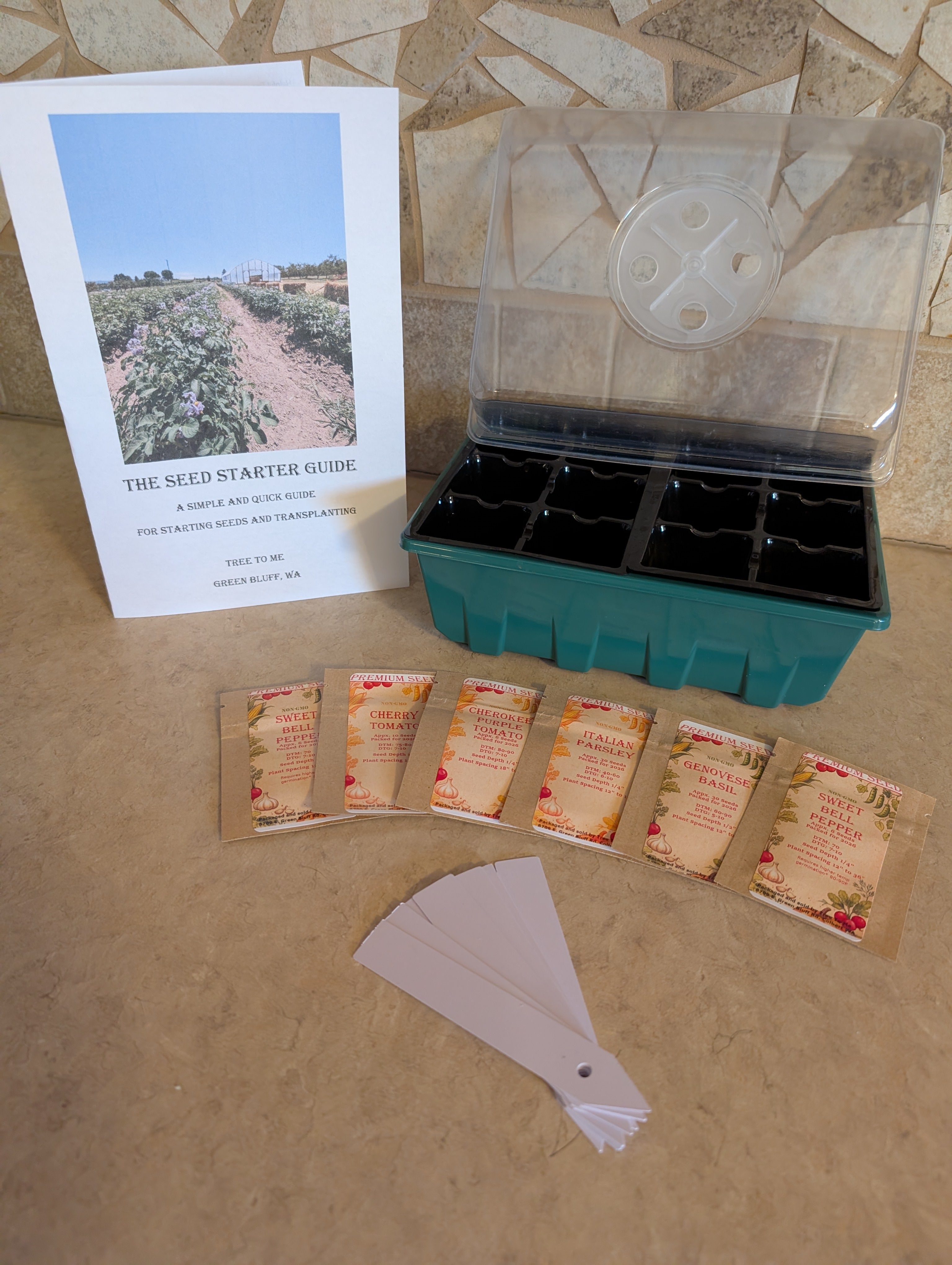 Seed starting kit with seed packets, starter guide, and tray on a tiled surface